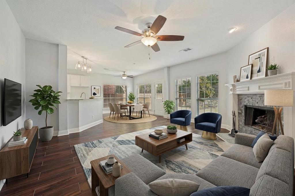 Wood-finish flooring throughout, ceiling fans, and a fireplace with stone surround