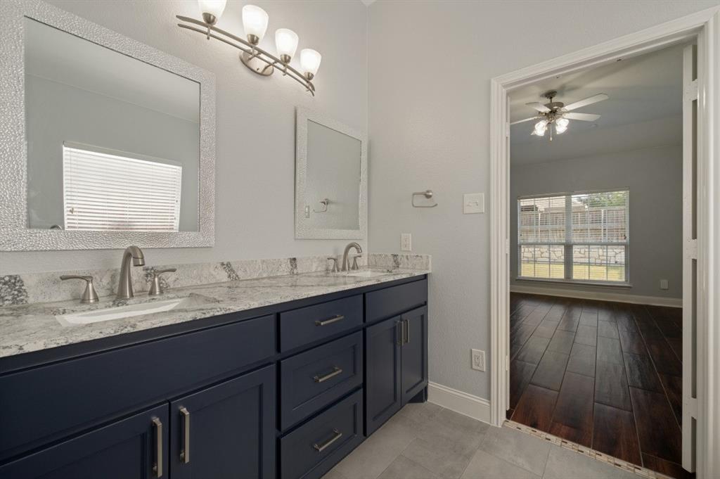 Dual vanity with a light-toned countertop, dark blue cabinetry, and satin nickel fixtures