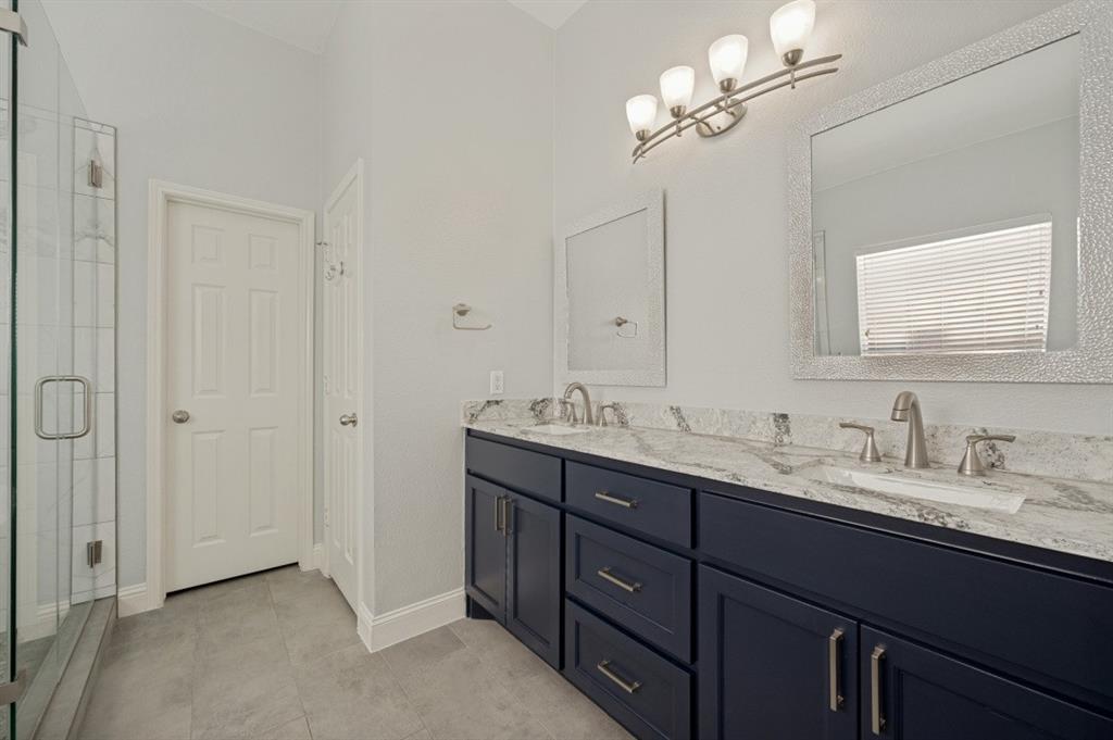 Dual vanity with stone countertop, undermount sinks, and dark wood-finish cabinetry