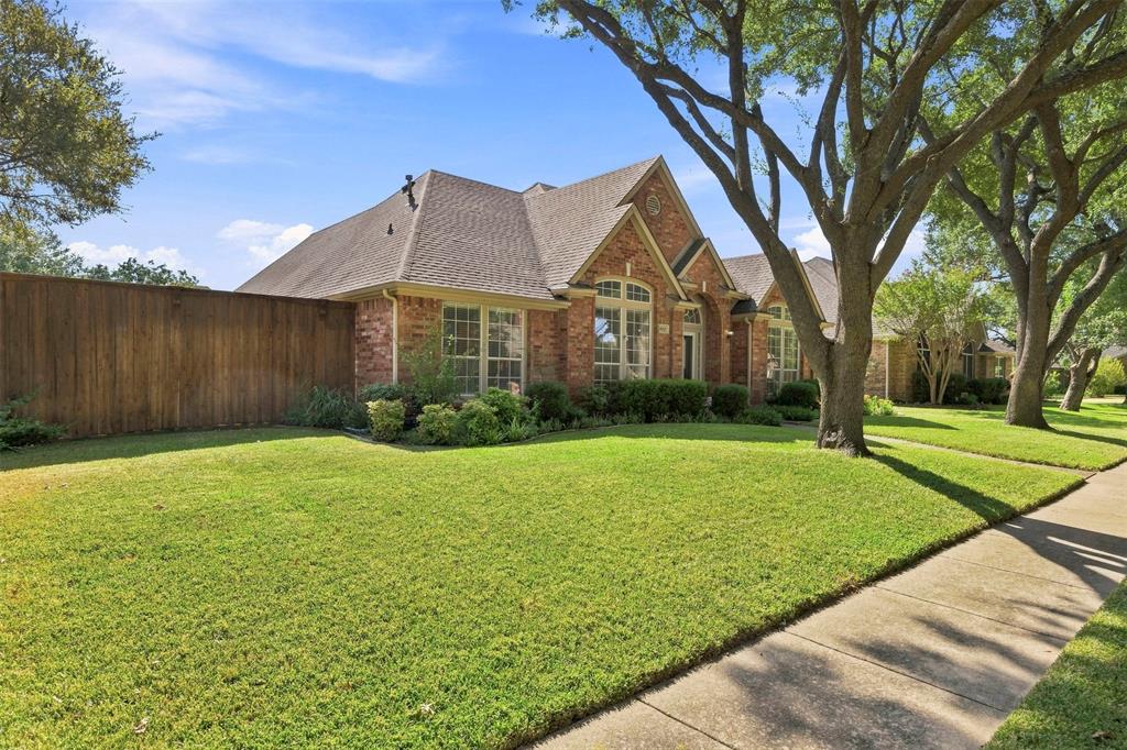 Brick exterior with a gabled roof and a wooden privacy fence Brick exterior with a gabled roof and a wooden privacy fence