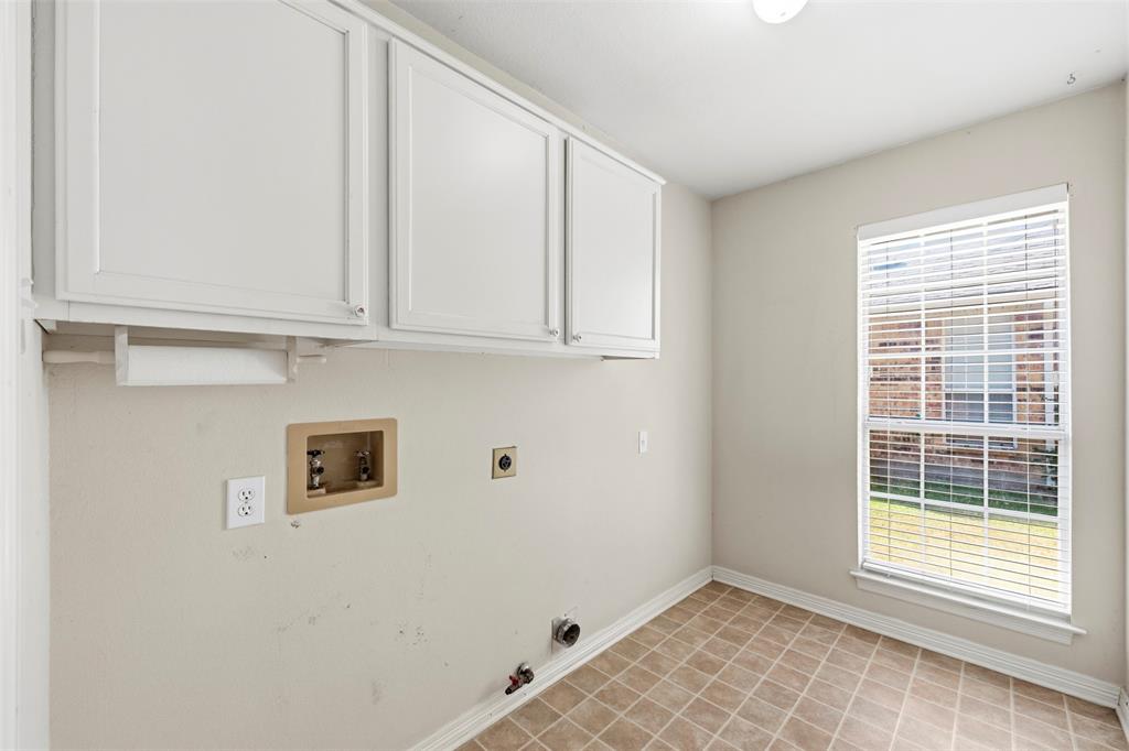 Upper cabinetry, tiled flooring, window with blinds, and white baseboards