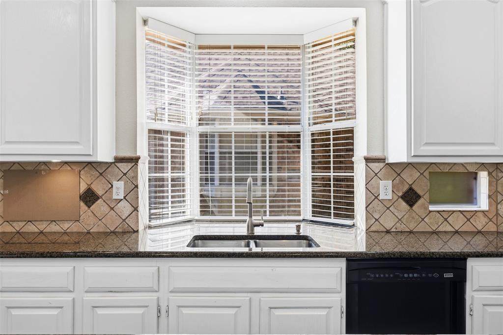 Bay window over a stainless steel double basin sink with a gooseneck faucet