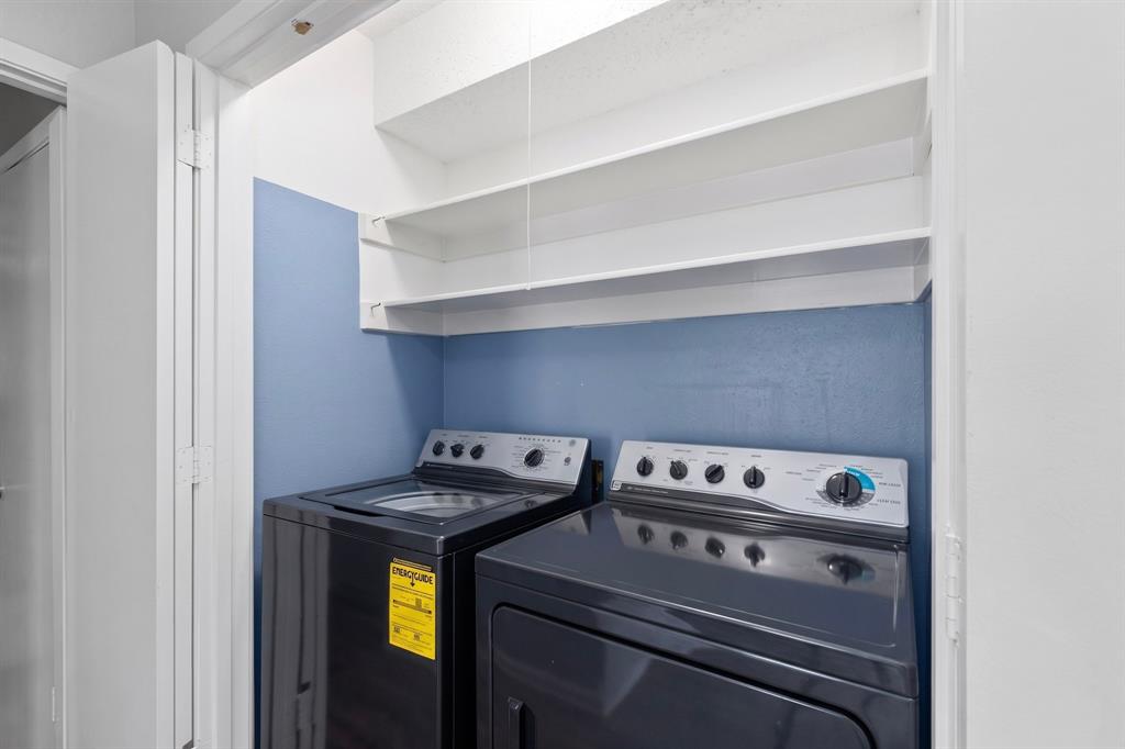 Laundry area with built-in shelving and appliances