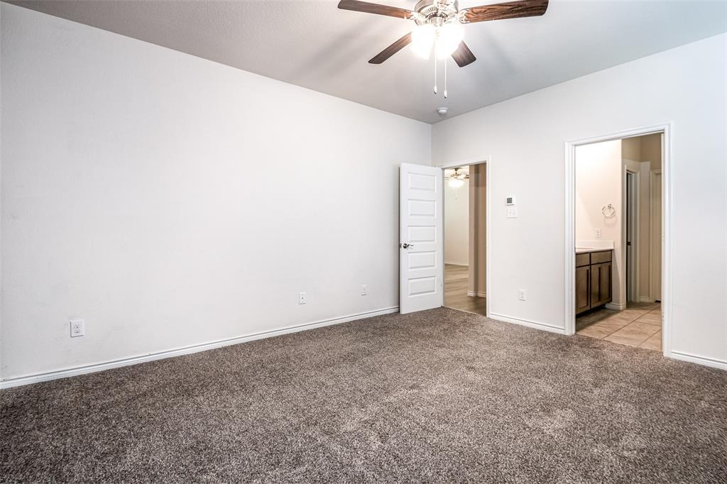 Expansive room featuring plush carpeting, a ceiling fan with integrated lighting, and a five-panel interior door