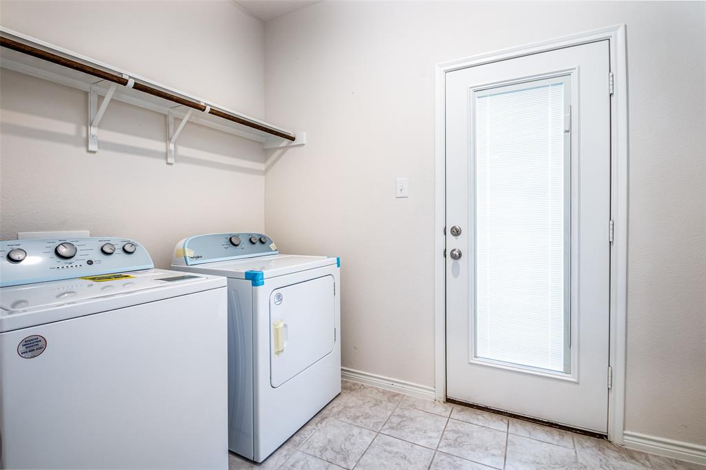 Laundry area featuring tile flooring, white walls, and an exterior door with an inset window
