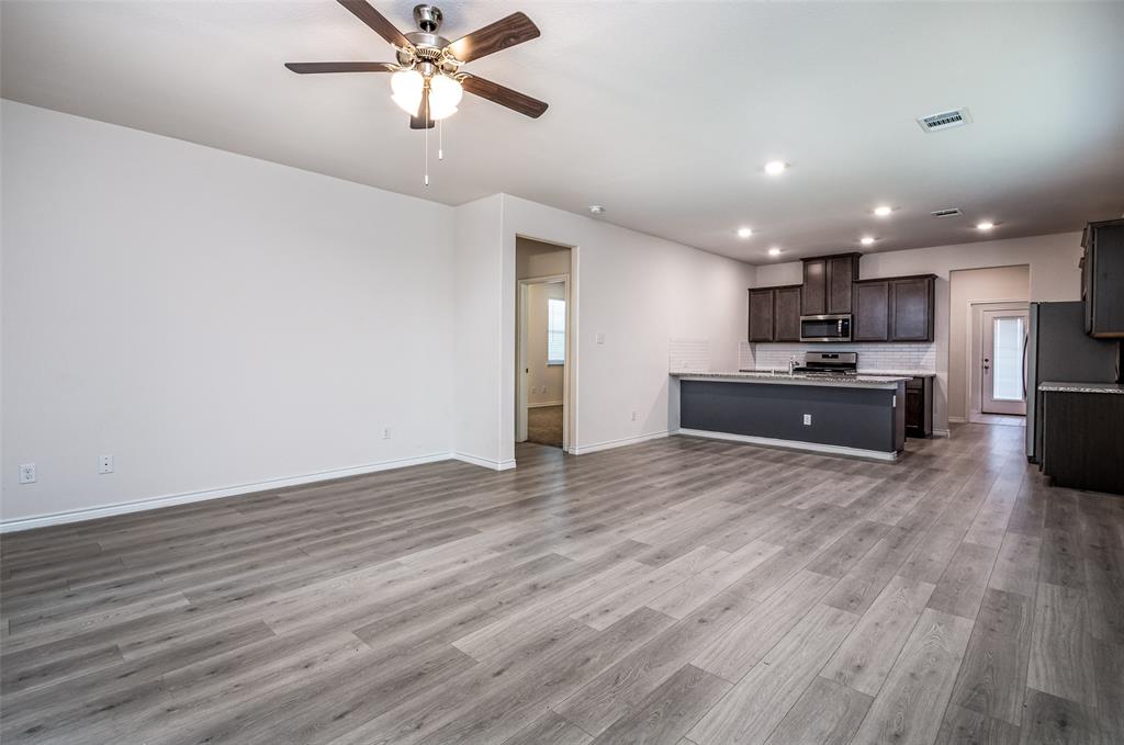 Open-concept living space featuring wood-finish flooring, recessed lighting, and a ceiling fan