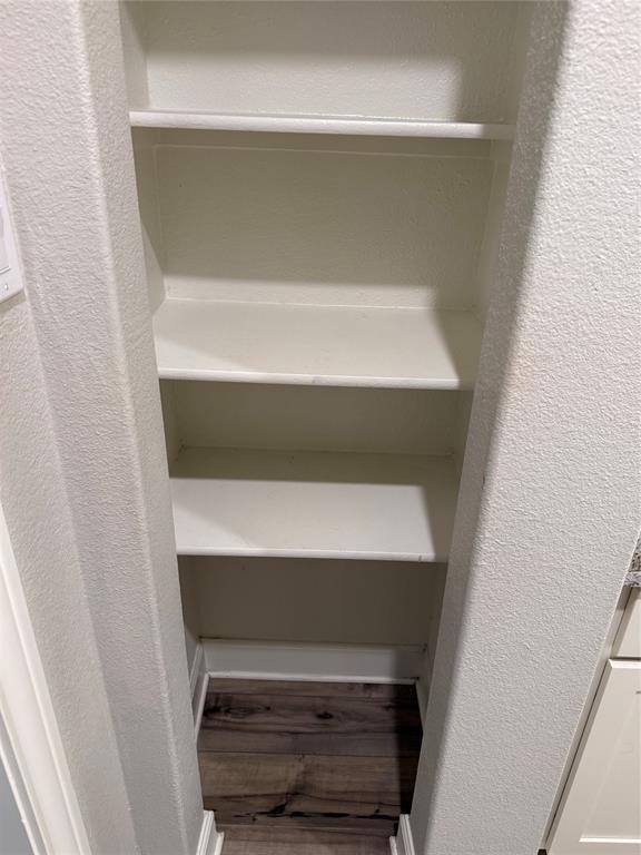 Built-in shelving with multiple storage levels and wood-finish flooring