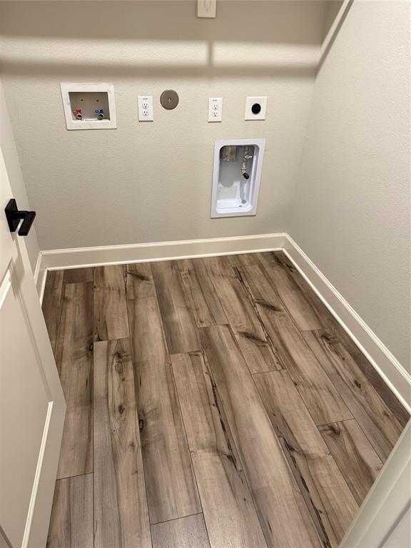 Wood-finish plank flooring with white baseboards