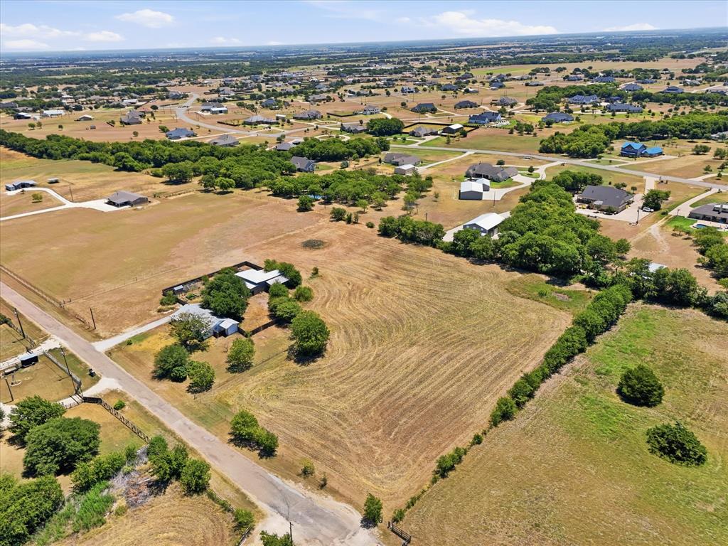 Expansive land parcel with surrounding residential properties, established roads, and scattered mature trees