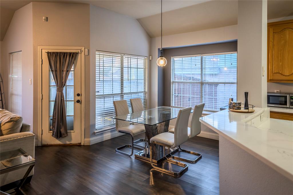 Vaulted ceilings, wood-finish flooring, and a glass-top dining table Vaulted ceilings, wood-finish flooring, and a glass-top dining table