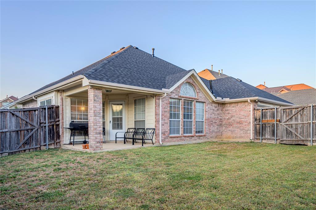 Brick exterior with a covered patio, gabled roofline, and arched window