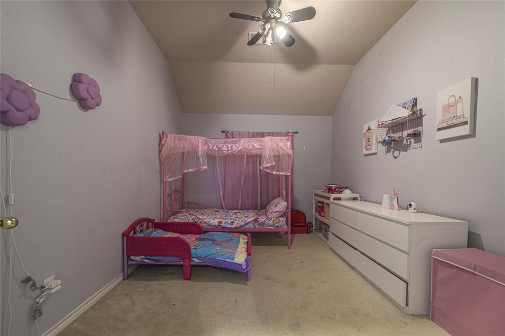 Vaulted ceiling, ceiling fan with integrated lighting, wall-to-wall carpeting, and light-toned wall finishes