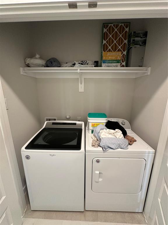 Laundry area with a white top-load washer and white dryer