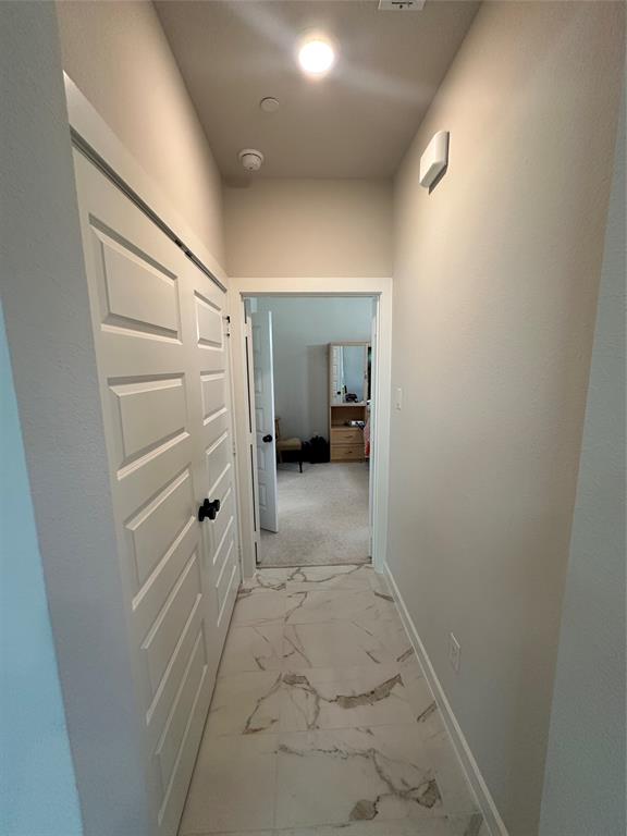 Hallway with patterned tile flooring, white paneled doors, and recessed lighting