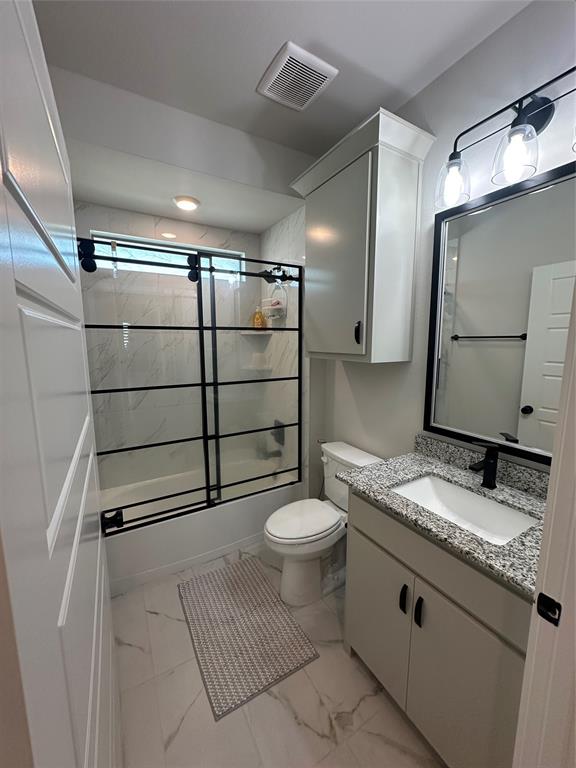 Bathroom featuring a built-in vanity with granite-finish countertop, a rectangular undermount sink, and a black-framed mirror