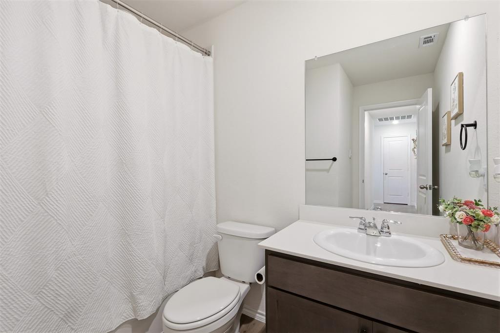 White vanity with dark wood-finish cabinetry, a white countertop, and an oval undermount sink