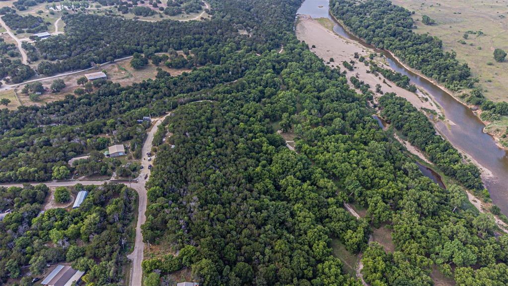 Riverfront property featuring extensive tree coverage, natural waterways, and unpaved roads