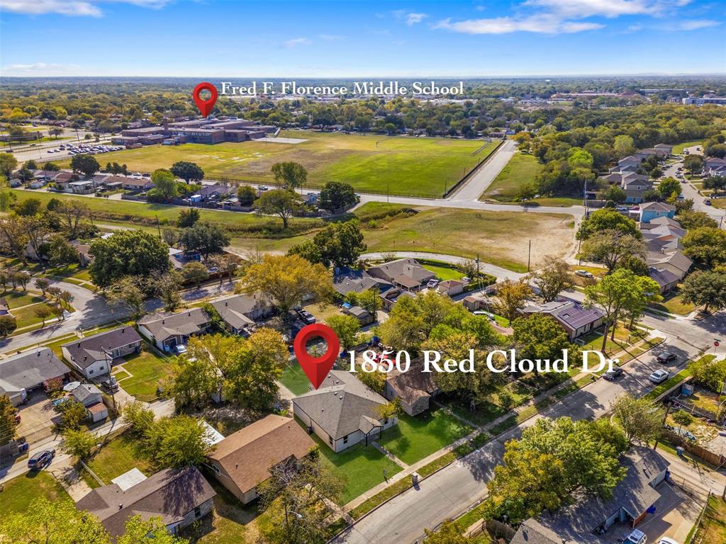 Aerial perspective of a single-story residential property featuring a composition shingle roof, a front-facing driveway, and a maintained lawn area
