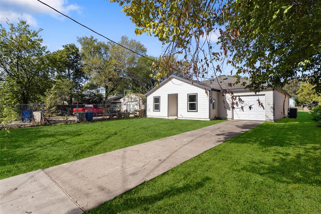Single-story residence featuring horizontal lap siding, an attached garage, and a paved concrete driveway situated on a grass-covered lot