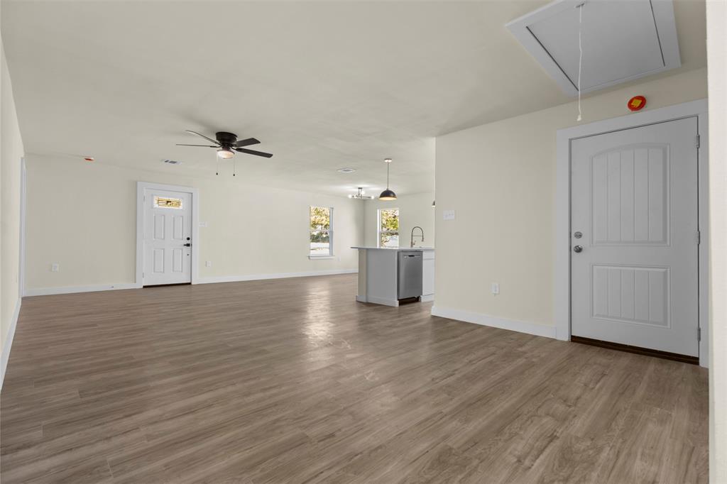 Open-concept interior featuring wood-finish flooring, ceiling fan, recessed lighting, and white panel doors