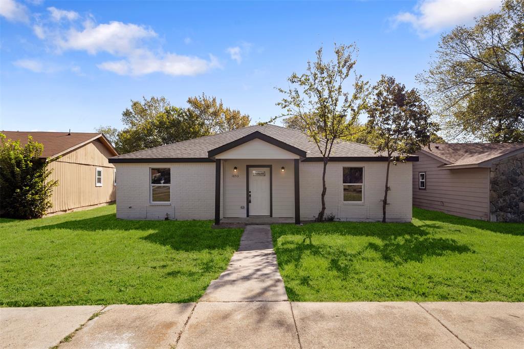 Single-story exterior featuring painted brick masonry, a covered front entryway, composition shingle roof, and a concrete walkway Single-story exterior featuring painted brick masonry, a covered front entryway, composition shingle roof, and a concrete walkway