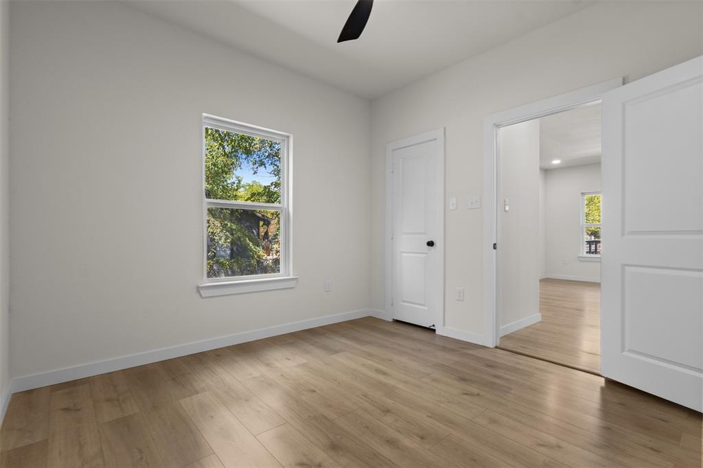 Light wood-finish flooring throughout, white walls, and a window with white trim