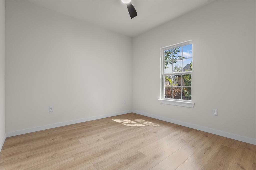 Wood-finish flooring, white walls, single window, and a ceiling fan