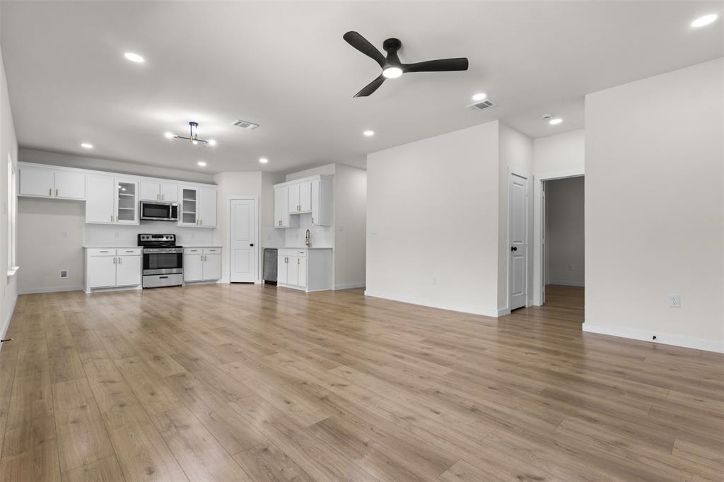 Open-concept living area featuring wood-finish flooring, recessed lighting, and a modern ceiling fan Open-concept living area featuring wood-finish flooring, recessed lighting, and a modern ceiling fan