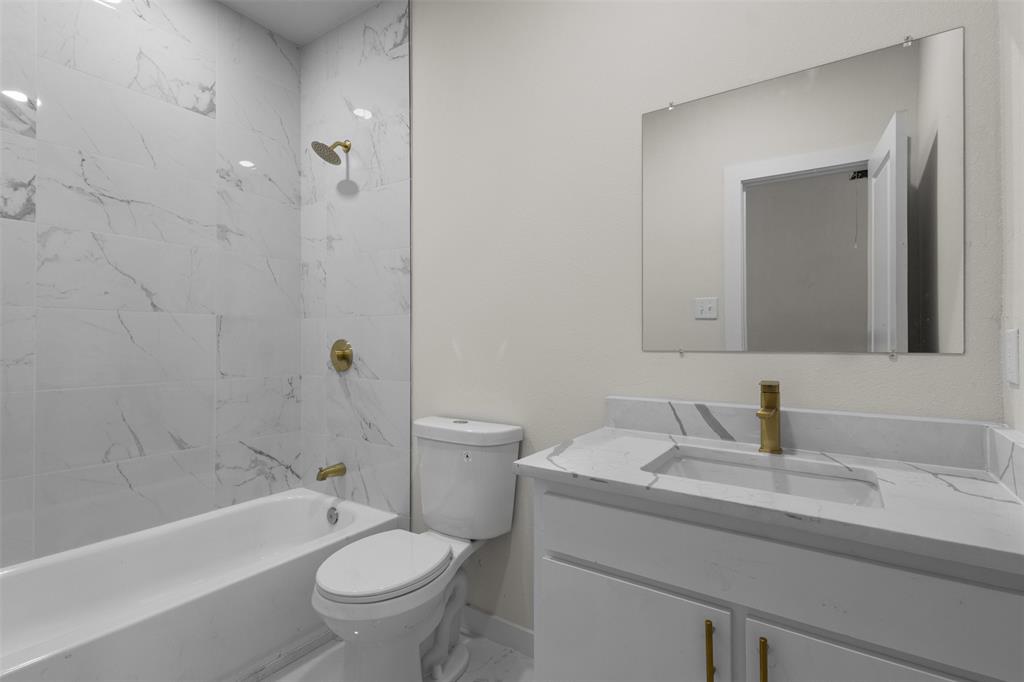 White vanity with integrated sink and gold-tone faucet