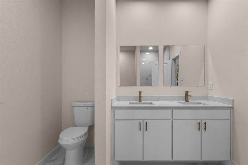 Dual vanity with light-toned countertop and gold-finish faucets