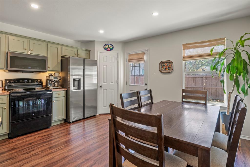 Wood-finish flooring throughout, stainless steel refrigerator, built-in microwave, and recessed lighting