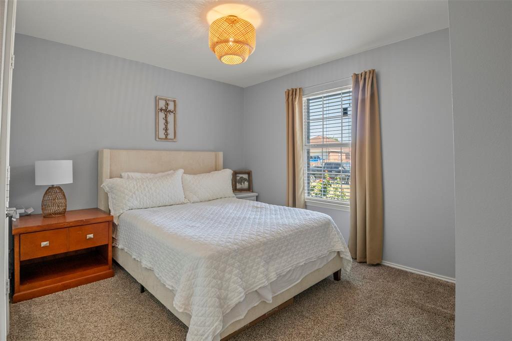 Carpeted room featuring a window with blinds and drapes, a light fixture, and light gray walls