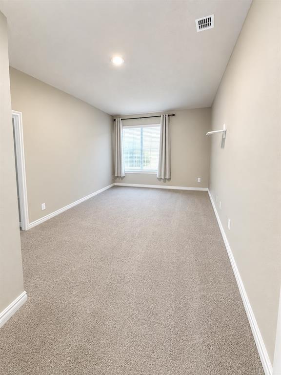 Plush carpet flooring, neutral paint tones, recessed ceiling lighting, and a window with blinds Plush carpet flooring, neutral paint tones, recessed ceiling lighting, and a window with blinds