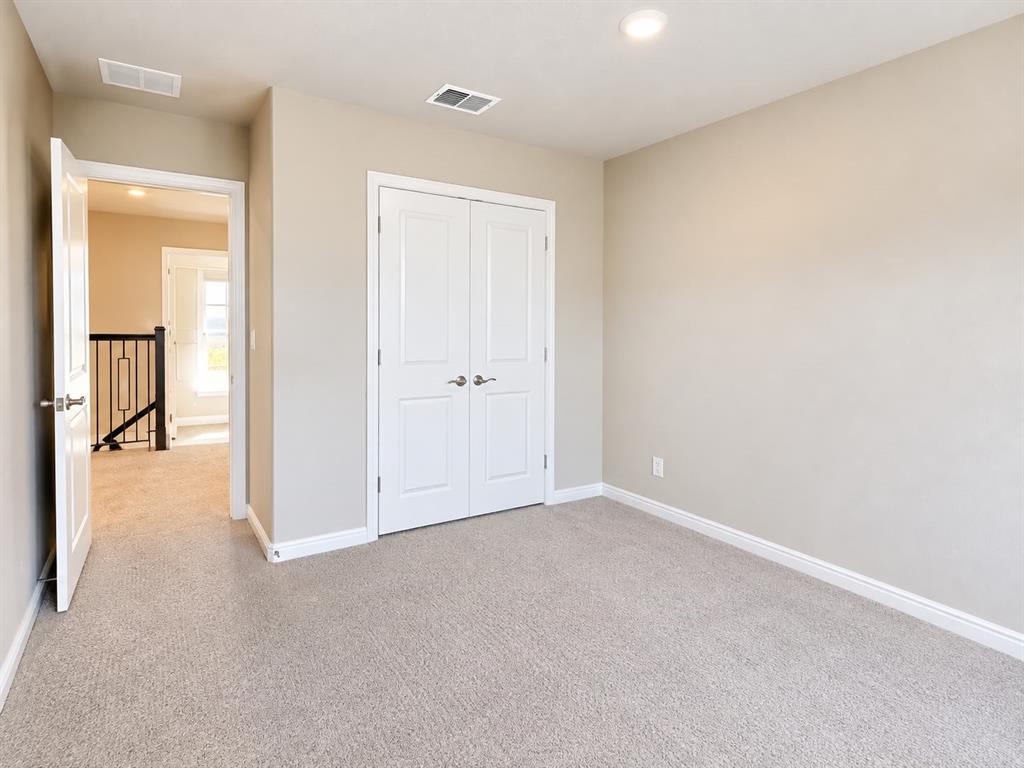 Neutral-toned carpeting throughout, recessed ceiling lighting, and white trim Neutral-toned carpeting throughout, recessed ceiling lighting, and white trim
