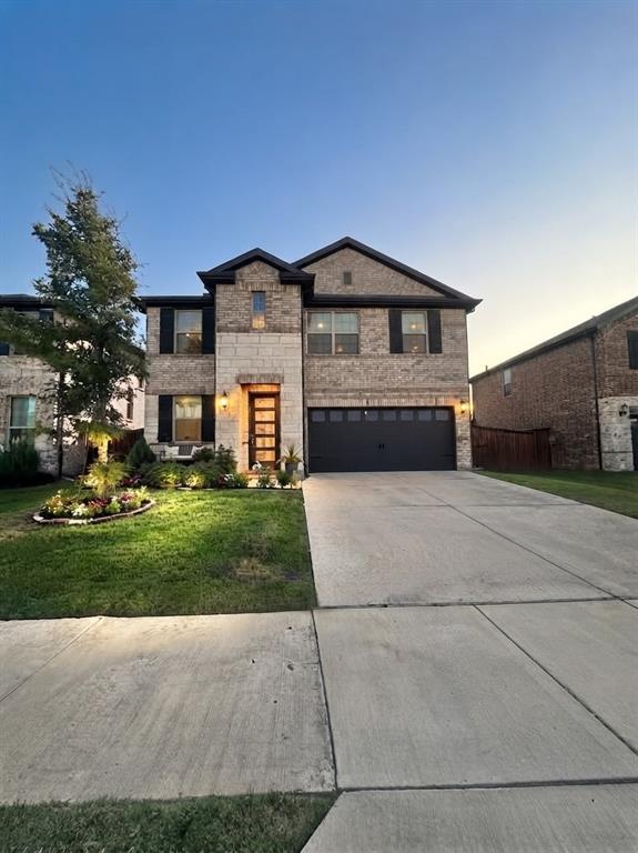 Two-story exterior with brick and stone-finish facade, two-car garage, and established landscaping Two-story exterior with brick and stone-finish facade, two-car garage, and established landscaping
