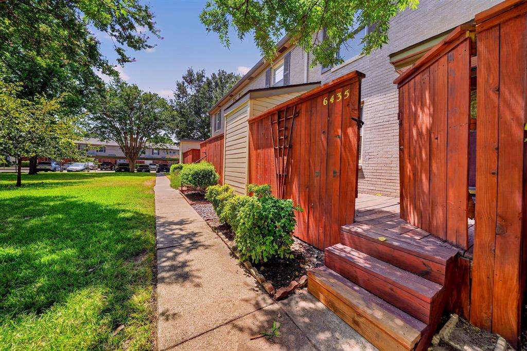 Back steps lead to the community greenbelt at the rear of the property.
