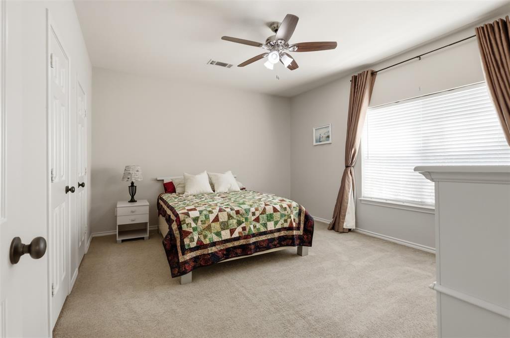 Secondary bedroom with large window and ceiling fan.