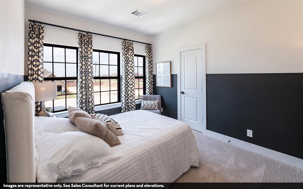 Three large windows with black frames, two-tone wall treatment, and white interior door with black hardware