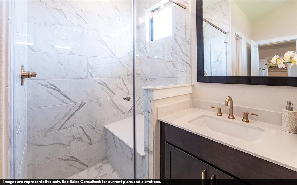 Walk-in shower with full-height marble-look tile, glass enclosure, and integrated bench