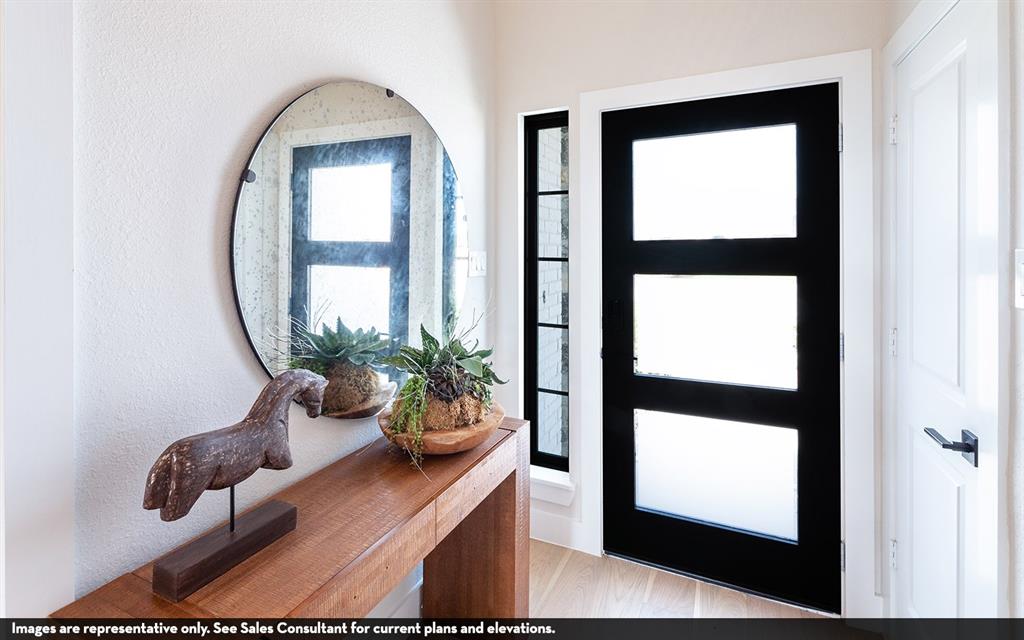 Warm wood-finish console table, round wall-mounted mirror, and sleek black entry door with frosted glass panels Warm wood-finish console table, round wall-mounted mirror, and sleek black entry door with frosted glass panels