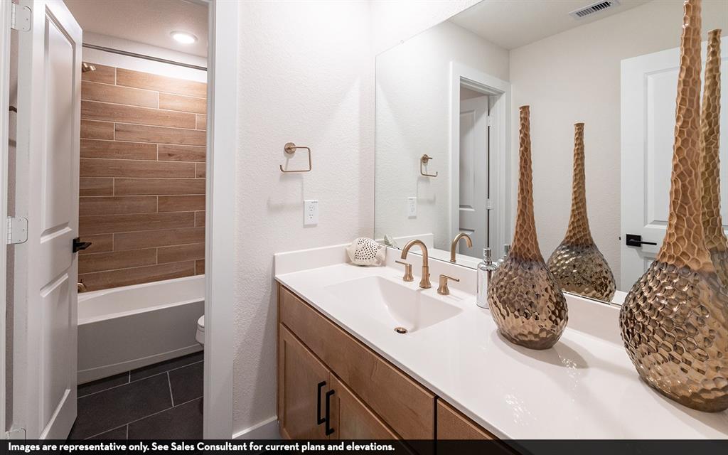 Vanity with a single undermount sink, brass-finish faucet, and white countertop