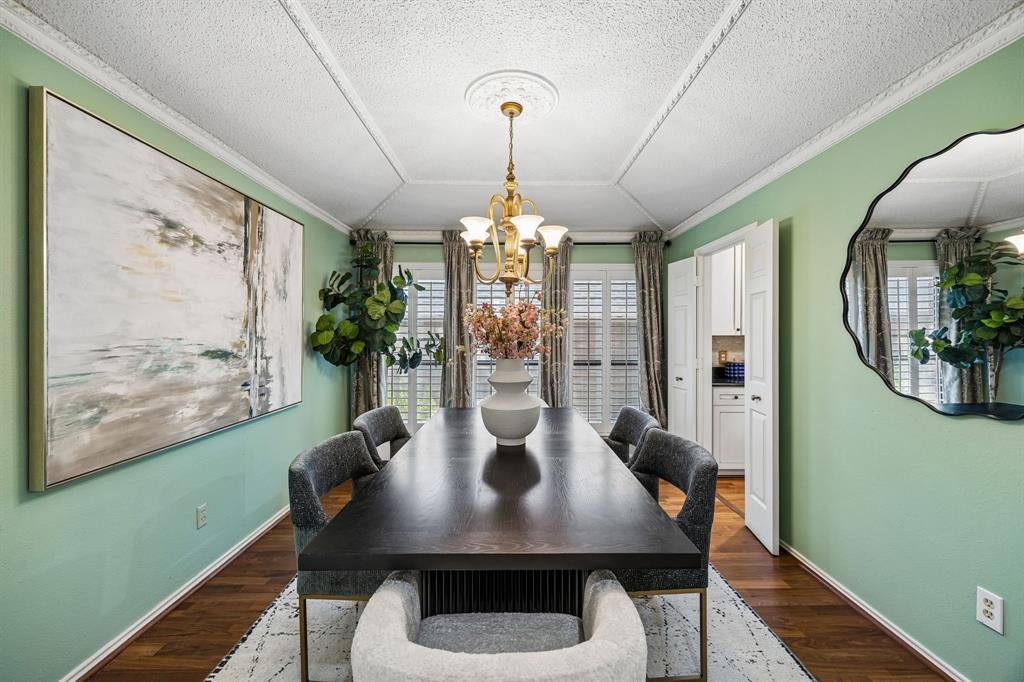 The dining room features plantation shutters, wood floors and original trim details.