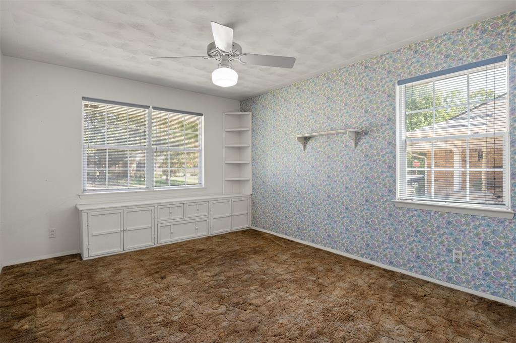 Built-in cabinetry with drawers, integrated shelving, ceiling fan with light fixture, and multiple windows
