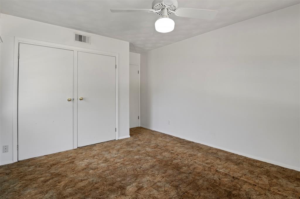 White walls with white trim, brown carpet, ceiling fan with integrated lighting, and white bi-fold closet doors