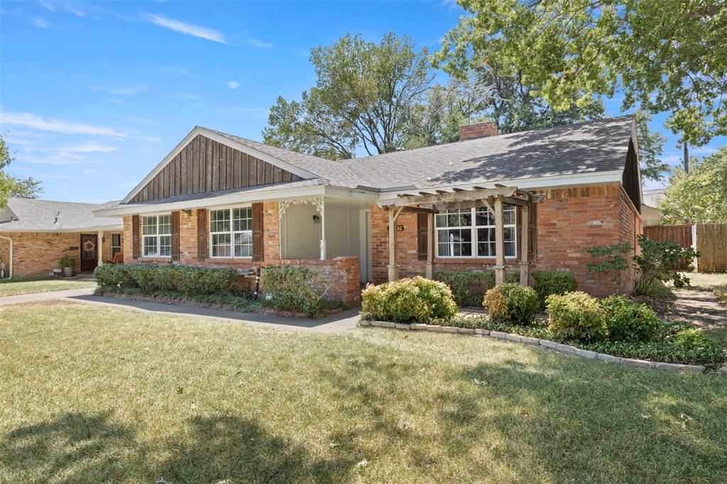 Brick exterior with wood shutters, front porch with decorative railing, and an integrated pergola Brick exterior with wood shutters, front porch with decorative railing, and an integrated pergola