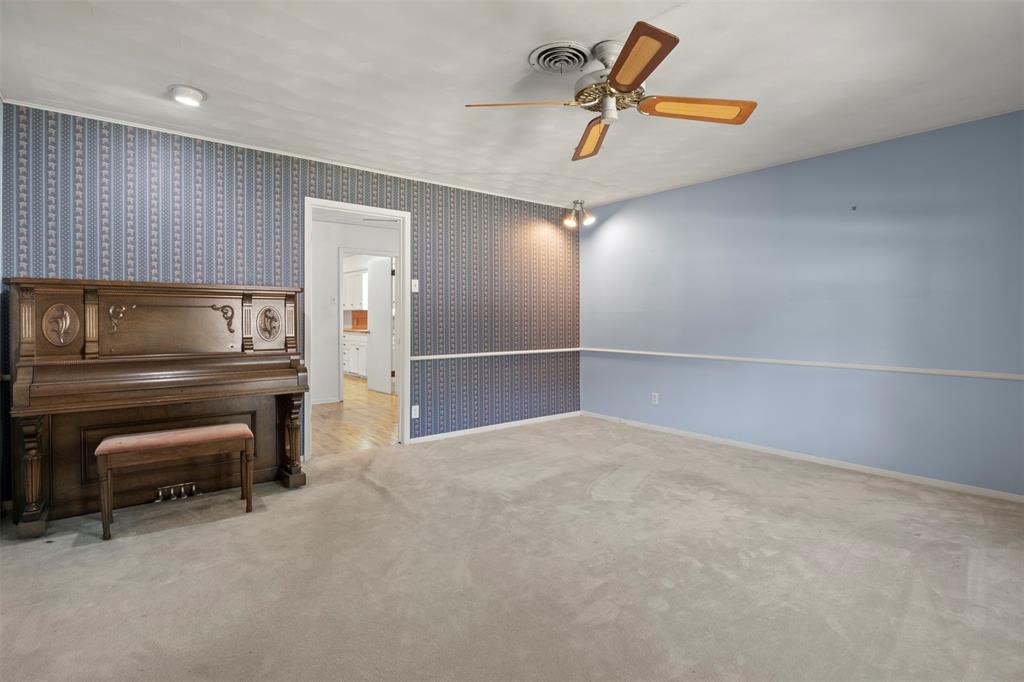 Recessed lighting, ceiling fan, textured wallpaper accent wall, wood-finish flooring visible through doorway, soft carpet Recessed lighting, ceiling fan, textured wallpaper accent wall, wood-finish flooring visible through doorway, soft carpet