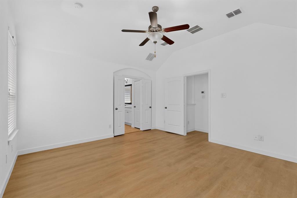 Vaulted ceilings, wood-finish flooring, and a ceiling fan with integrated lighting