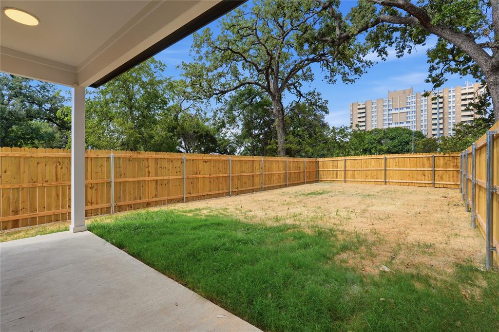Covered patio with a concrete surface, enclosed by a wood privacy fence