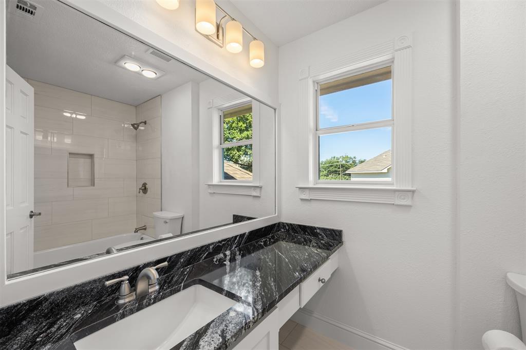 Upstairs hall bathroom has granite countertop, new sink with brushed nickel faucet, new tub and shower with brushed nickel faucets.  New tile has been installed surrounding the tub area and on floors.  A new Kohler toilet along with new lighting fixtures have been installed.  The tub surround tile and floor are white.