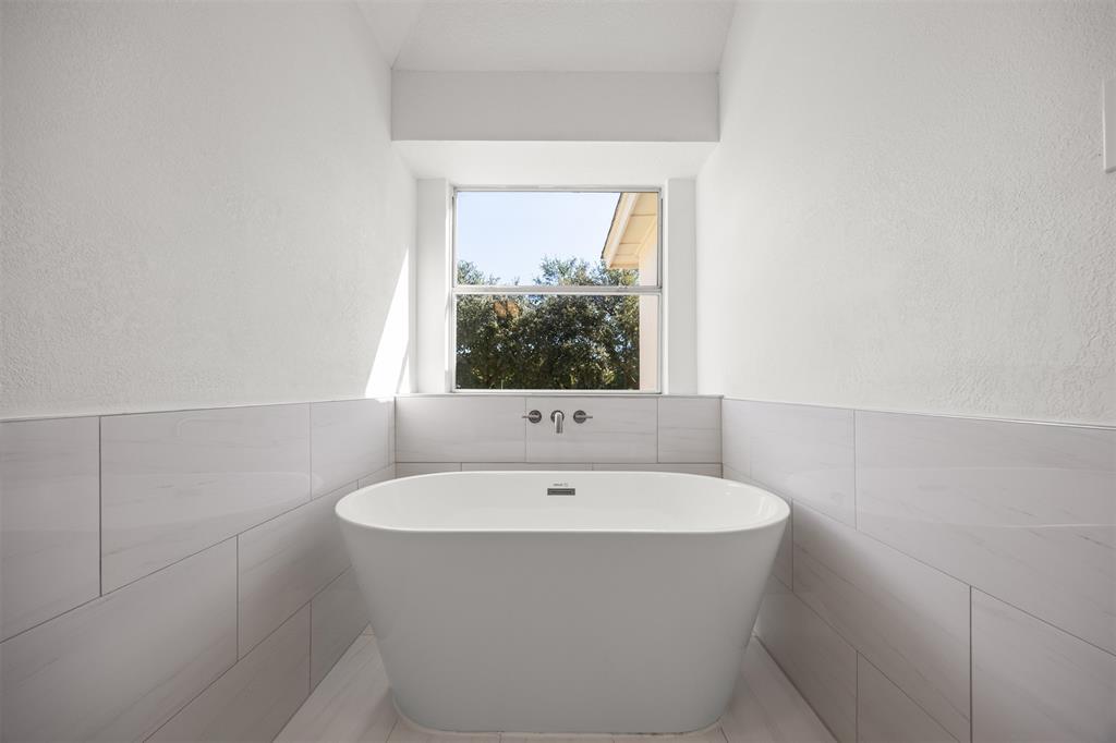 Master Bath with soaking tub, new tile flooring in master bath with wall tile installed to approximately 4 feet.